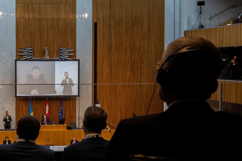 Austrian President Alexander Van der Bellen listens, as Ukrainian President Volodymyr Zelenskiy addresses Austria's lower house of parliament by video link in Vienna, Austria, March 30, 2023. REUTERS/Lisa Leutner