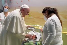 Pope Francis baptises a baby boy as he visits the children&#39;s cancer ward at the Gemelli hospital where he was hospitalised for a respiratory infection [Vatican Media/Handout via Reuters]