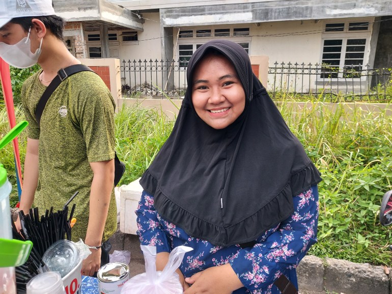 Dewi Putri smiles from behind her stall.