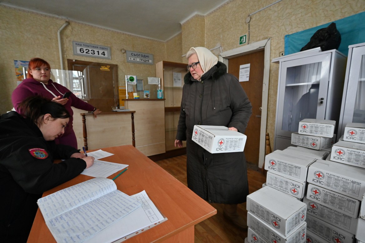 A local resident receives humanitarian aid supplies in premises of a post office in the village of Dubivka, Kharkiv region