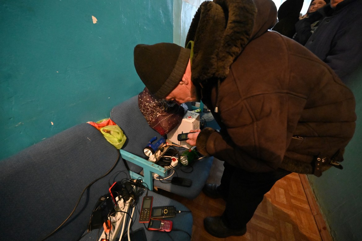 Local residents charge their devices in a rural outpatient clinic, equipped with a generator and satellite internet due to lack of electricity, in the village of Dubivka, Kharkiv