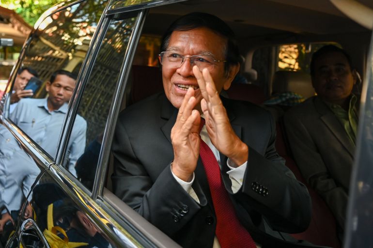 Kem Sokha greeting supporters from his car as he heads to court in Phnom Penh for the verdict in his treason trial. He is smiling and looks relaxed.