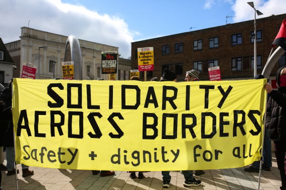 People hold placards as they gather in central Dover to attend a 'Refugees Welcome' rally organised by Stand Up To Racism on the south-east coast of England, on March 4, 2023, as pro-and anti-migrant demonstrations take place in the town. - More than 45,000 migrants crossed the Channel to the UK from mainland Europe in 2022, surpassing the previous year's record by more than 17,000. (Photo by Susannah Ireland / AFP)