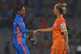 Mumbai Indians' captain Harmanpreet Kaur (L) shakes hands with Gujarat Giants' Ashleigh Gardner at the end of the 2023 Women's Premier League (WPL) Twenty20 cricket match between Gujarat Giants and Mumbai Indians at the DY Patil Stadium in Navi Mumbai on March 4, 2023