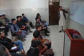 Male students attend their computer science class after the universities were reopened in Kabu