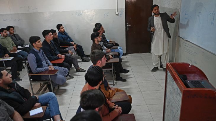 Male students attend their computer science class after the universities were reopened in Kabu
