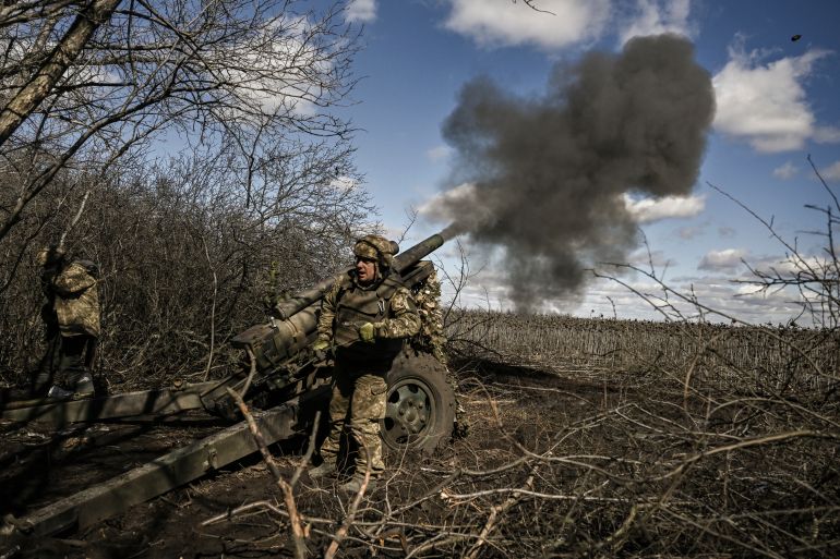 Ukrainian service members fire at Russian positions with a 105mm howitzer in the region of Donbas, Ukraine.