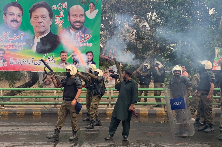 Riot police fire teargas shells to push back supporters of former prime minister Imran Khan gathered outside Khan's house to prevent officers from arresting him, in Lahore on March 14, 2023. (Photo by Arif ALI / AFP)