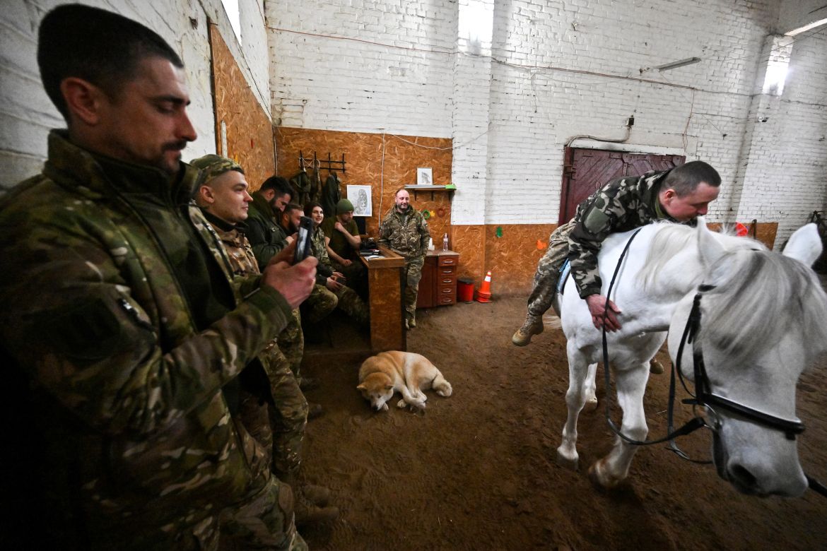 A Ukrainian serviceman rides a horse during a hippotherapy session in Kyiv