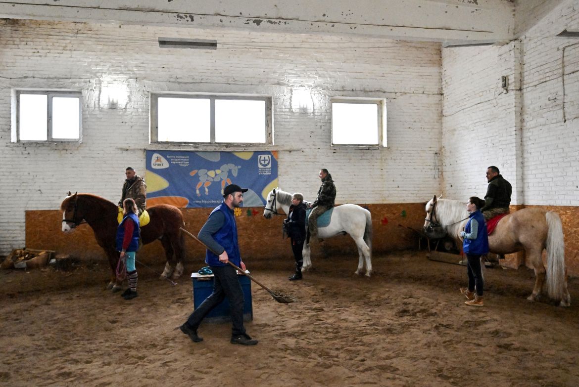 Ukrainian servicemen ride horses during a hippotherapy session in Kyiv