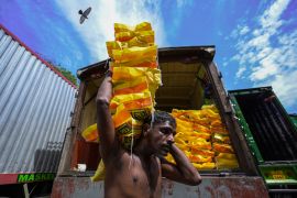 A labourer unloads a sack of rice from a truck at a market in Colombo on March 20 [Ishara S. Kodikara/AFP]