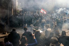 Tear gas fumes fill the air as retired Lebanese army and security forces veterans attempt to break into the government palace premises in the centre of Beirut [Joseph Eid/AFP]