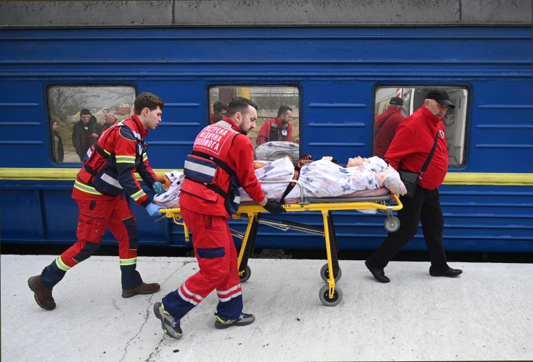 Nhân viên y tế sơ tán thường dân bị thương.