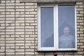 Alexei Moskalyov looks out through the window of his flat after he was placed under house for repeating Ukraine posts discrediting the Russian army, in the town of Yefremov