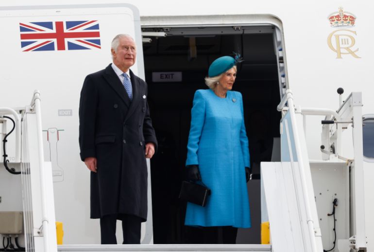 Britain's King Charles III (L) and Britain's Camilla, Queen Consort get off their plane