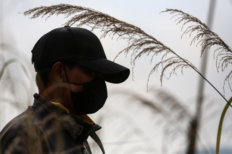 Askerden kaçan Kyaw'ın profil fotoğrafı.  Gökyüzüne karşı kontrast oluşturuyor ve kimliğini gizlemek için bir maske ve beyzbol şapkası takıyor.