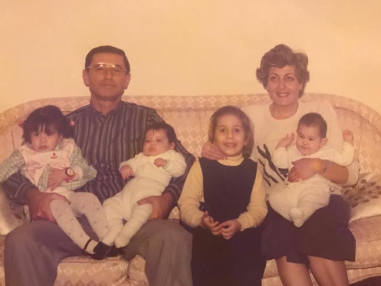 Old family photo of two parents and their four young children. 