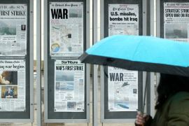 Newspapers on a wall, showing headlines about the Iraq war
