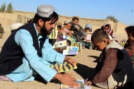 Afghans volunteers of Pen Path Civil Society distribute books during an educational awearness camapign in Kandahar.