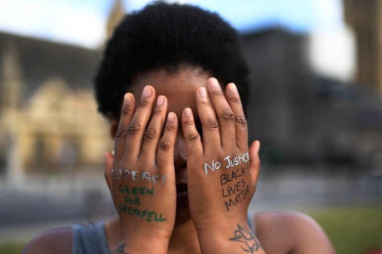 A woman symbolically covers her eyes as she participates in a Black Lives Matter protest calling for an end to racial injustice, at the Parliament Square in central London
