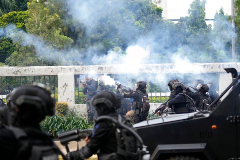 Police fire tear gas to disperse protesters during a rally in Jakarta, Indonesia, Monday, April 11, 2022. Thousands of students marched through cities across Indonesia on Monday to protest against rumors that the government was considering postponing the 2024 presidential election to allow President Joko Widodo to stay in office beyond the legal two-term limit, calling him a threat to the country's democracy.  (AP Photo/Tatan Syuflana)