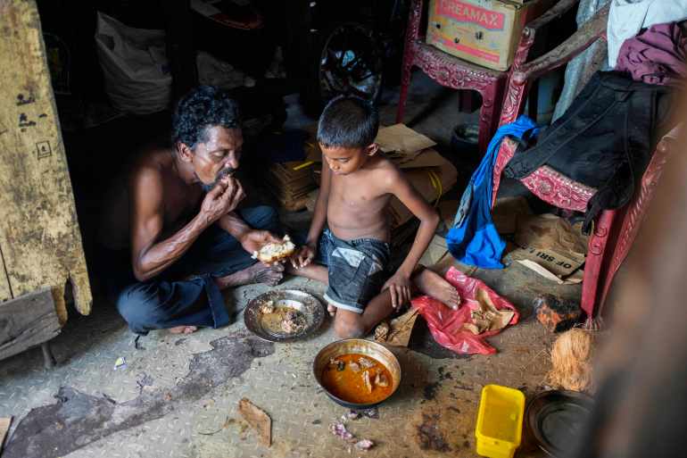 A father and son share a meal at their shanty in Colombo, Sri Lanka, Wednesday, Oct. 5, 2022. International creditors should provide debt relief to Sri Lanka to alleviate suffering as its people endure hunger, worsening poverty and shortages of basic supplies, Amnesty International said in a statement Wednesday. (AP Photo/Eranga Jayawardena)