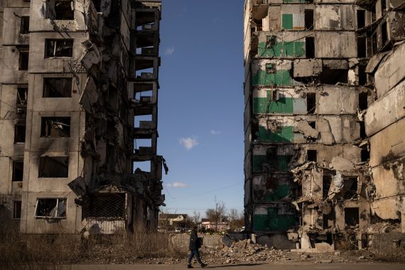 A man walks by an apartment block missing its central section after being hit by an airstrike, one year ago, in Borodyanka, Ukraine, Thursday, March 2, 2023. Nearly a year after towns and villages near Kyiv were retaken from Russian troops who had seized territory as they raced toward Kyiv at the start of their invasion of Ukraine, authorities are still exhuming the bodies of civilians hastily buried in makeshift graves. (AP Photo/Vadim Ghirda)