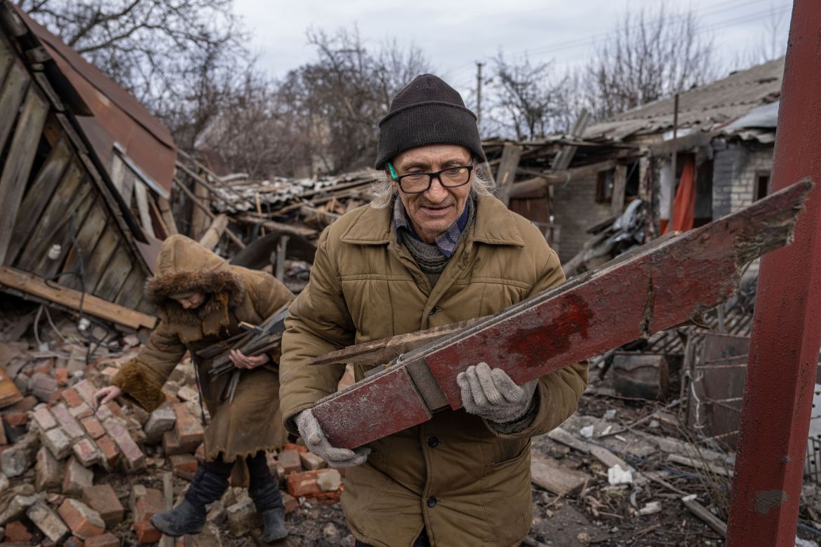 Hennadiy Mazepa and his wife Natalia Ishkova collect wood from a house which was destroyed by Russian forces in Chasiv Yar, Ukraine