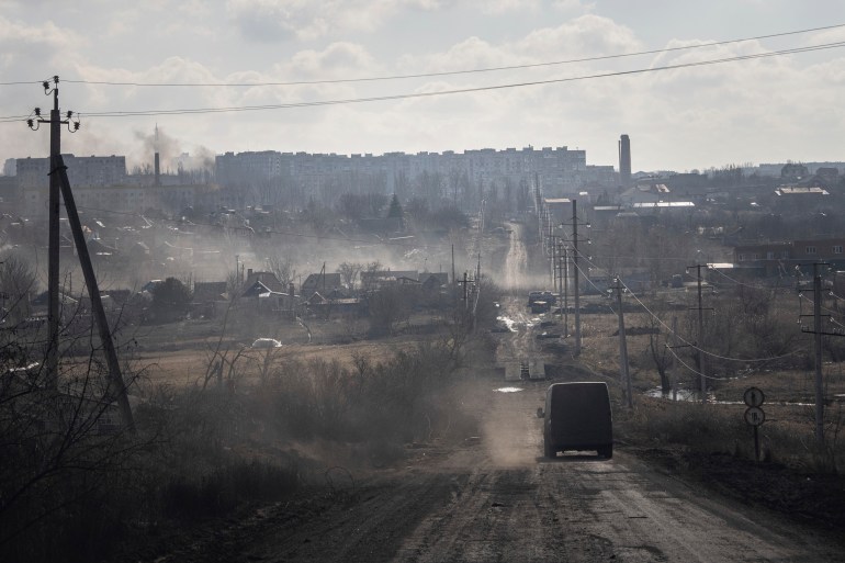 A Ukrainian police van drives on the highway for evacuation civilians in Khromove near Bakhmut