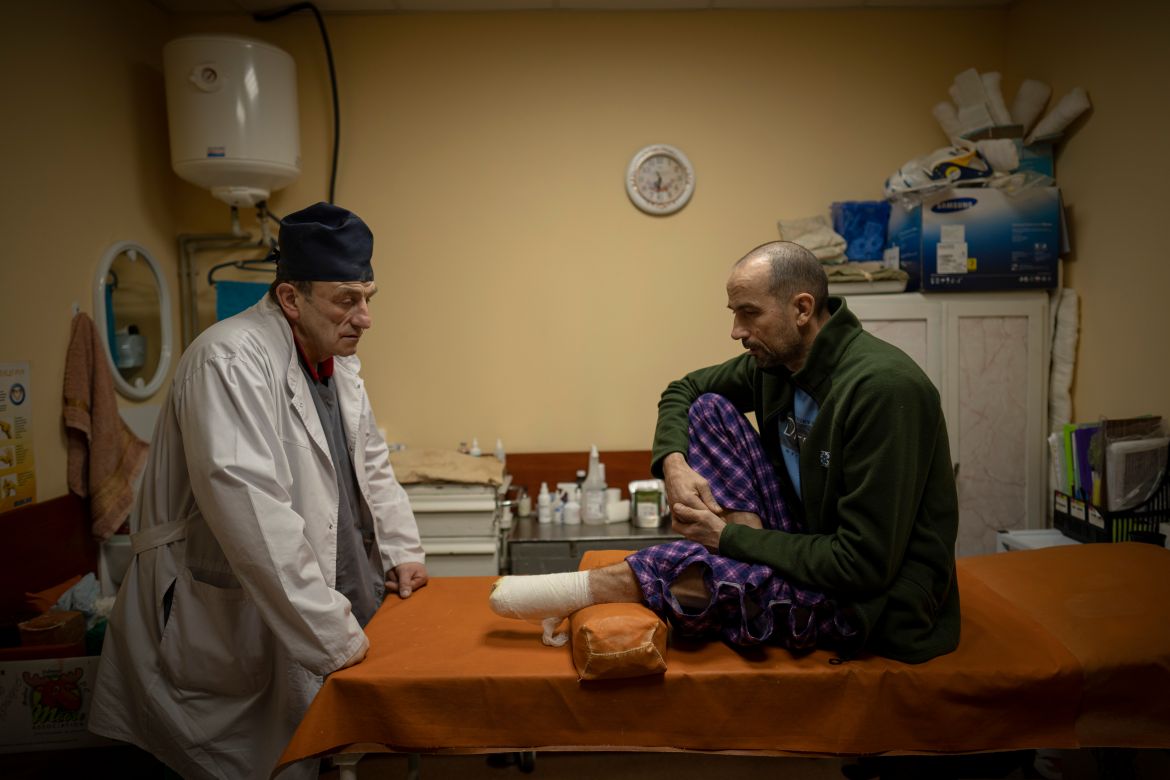 Ukrainian doctor Yurii Kuznetsov speaks to land mine victim Oleksandr Kolisnyk at the hospital in Izium, Ukraine