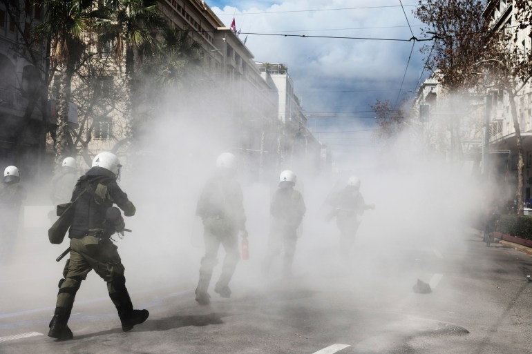 Çevik kuvvet polisi, 5 Mart 2023 Pazar, Yunanistan'ın Atina kentindeki çatışmalar sırasında göstericilere karşı operasyon yapıyor. 