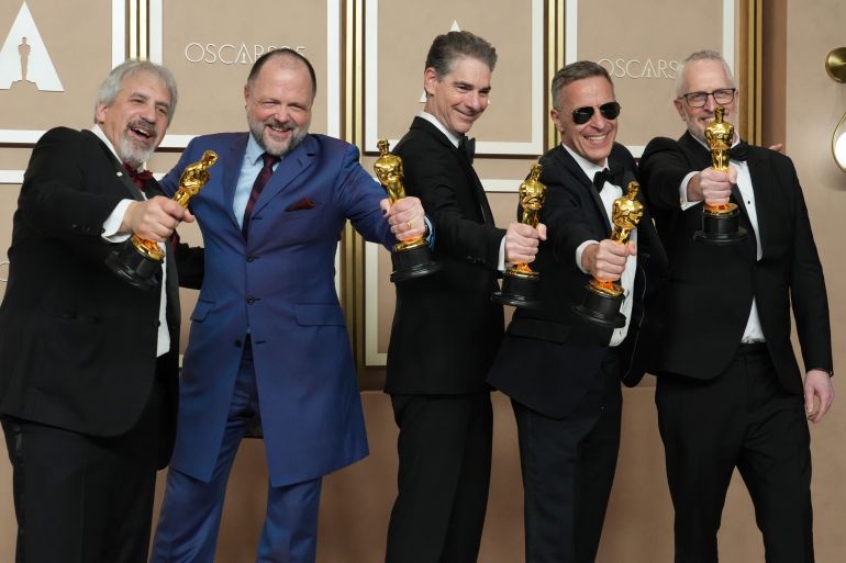 Five men hold out their Oscars