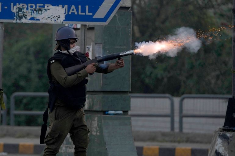 A riot police officer fires tear gas to disperse supporters of former Prime Minister Imran Khan