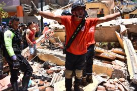 A rescue worker shouts from the debris of a home that collapsed when an earthquake shook Machala, Ecuador.