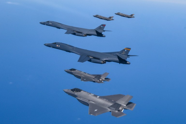 .S. Air Force B-1B bombers, center, fly in formation with South Korea's Air Force F-35A fighter jets 