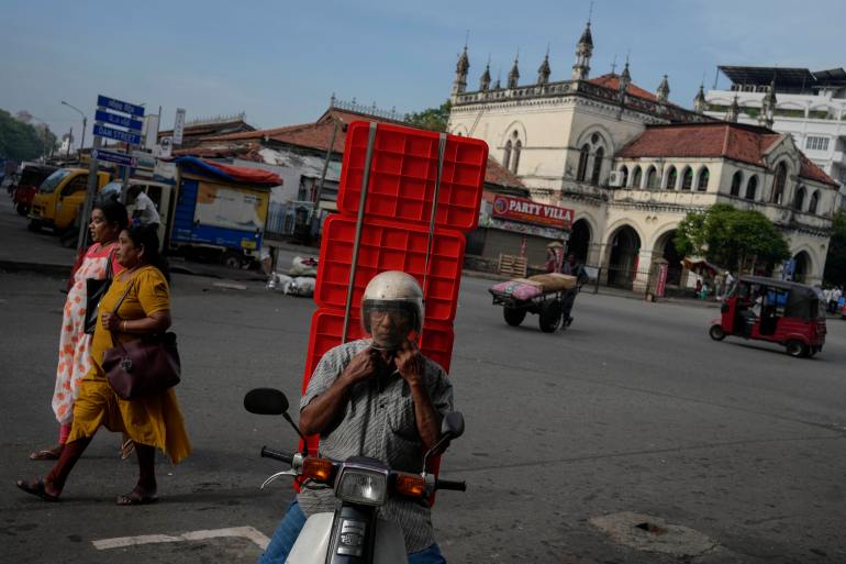 A Sri Lankan trader arrives at a market place for business in the morning in Colombo, Sri Lanka, Tuesday, March 21