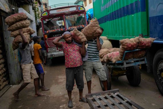 Laborers load sacks of imported potatoes to hand carts at a market place in Colombo, Sri Lanka, Tuesday, March 21, 2023.