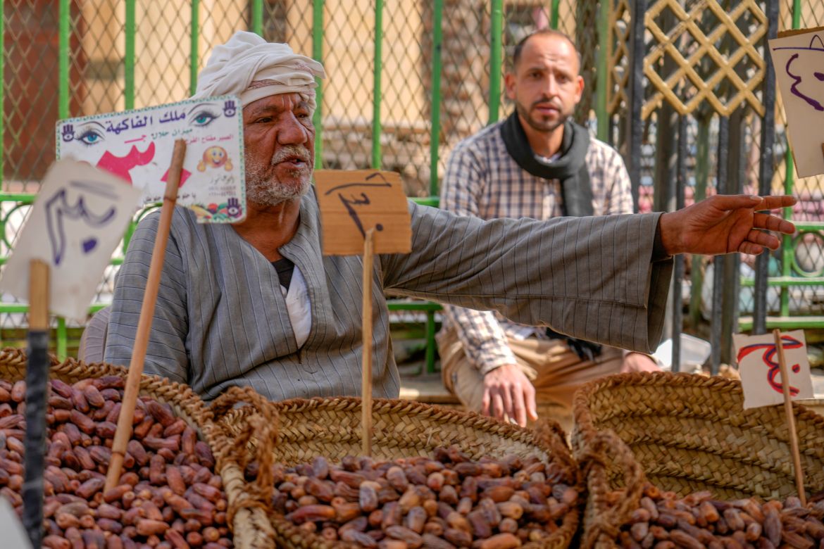 An Egyptian dates vendor talks to a client in Sayyeda Zeinab market ahead of the upcoming Muslim fasting month of Ramadan, in Cairo, Egypt
