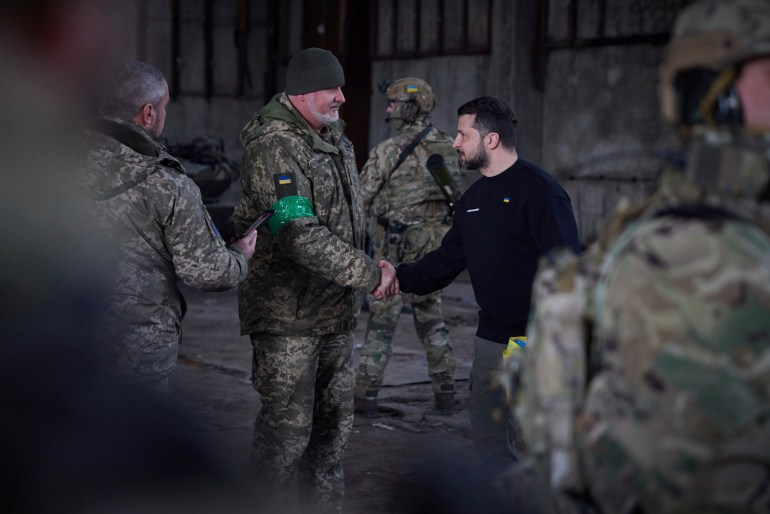 In this photo provided by the Ukrainian Presidential Press Office, Ukrainian president Volodymyr Zelenskyy shake hands with a soldier during an awarding ceremony at a position near Bakhmut, Donetsk region, Ukraine, Wednesday, March 22, 2023. (Ukrainian Presidential Press Office via AP)