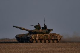 Ukrainian soldiers ride atop a tank on the frontline in Bakhmut, Donetsk region [Libkos/AP Photo]