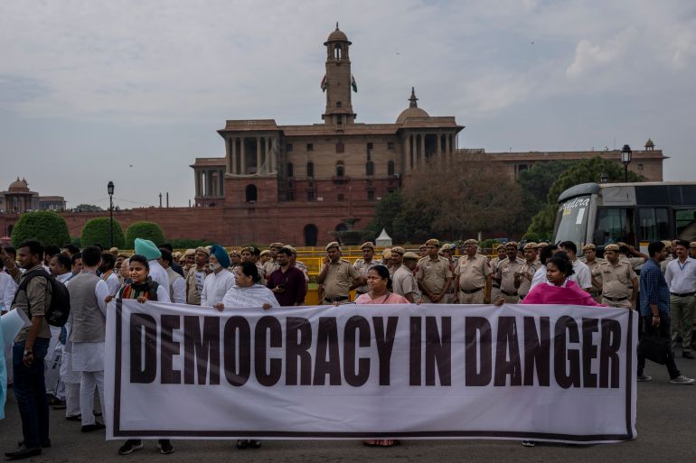 Lawmakers from India's opposition Congress and other parties hold a banner as they march against the Narendra Modi-led government alleging that Indian democracy is in danger, during a protest outside India's parliament in New Delhi, India, Friday, March 24, 2023. Key Indian opposition Congress party leader Rahul Gandhi lost his parliamentary seat as he was disqualified following his conviction by a court that found him of guilty of defamation over his remarks about Prime Minister Narendra Modi's surname, a parliamentary notification said on Friday. (AP Photo/Altaf Qadri)