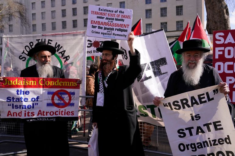 Protestors show placards during the visit of Israeli Prime Minister Benjamin Netanyahu