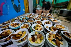 A volunteer prepares food plate to be distributed among people for breaking their fast during the Muslims holy fasting month of Ramadan, in a mosque, in Rawalpindi, Pakistan. (AP Photo/Anjum Naveed) (AP Photo)