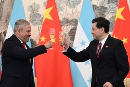 Honduran Foreign Minister Eduardo Enrique Reina Garcia and Chinese Foreign Minister Qin Gang make a toast after the establishment of diplomatic relations between their two countries [Greg Baker/AP]