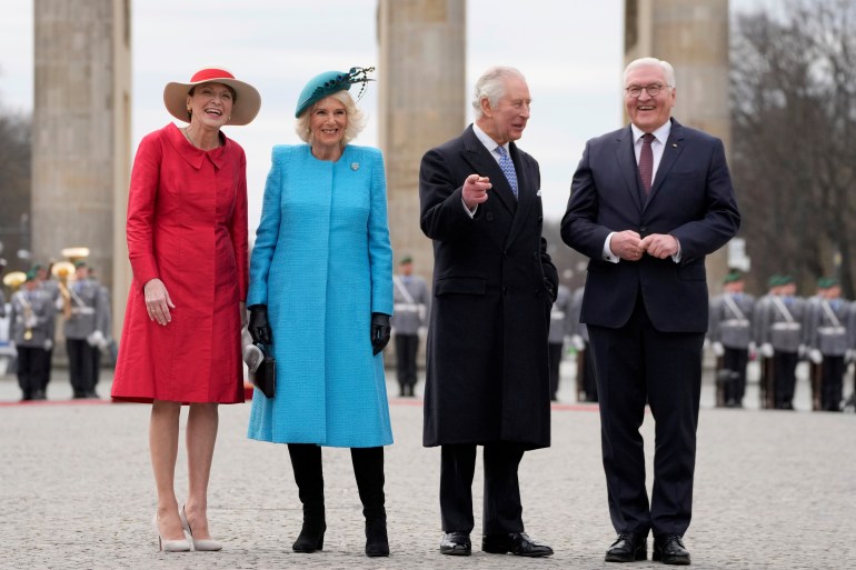 German President Frank-Walter Steinmeier, right, and his wife Elke Buedenbender, left, welcome Britain's King Charles III and Camilla, the Queen Consort, in front of the Brandenburg Gate in Berlin