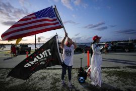 Trang Le of Orlando, right, and Maria Korynsel of North Palm Beach show their support for former President Donald Trump after the news broke that Trump has been indicted by a Manhattan grand jury, Thursday, March 30, 2023, near Trump’s Mar-a-Lago estate in Palm Beach, Fla. (AP Photo/Rebecca Blackwell)