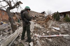 A Ukrainian serviceman documents destruction of a house which was destroyed by a Russian rocket in Kharkiv, Ukraine, Friday, March 31, 2023. (AP Photo/Andrii Marienko)