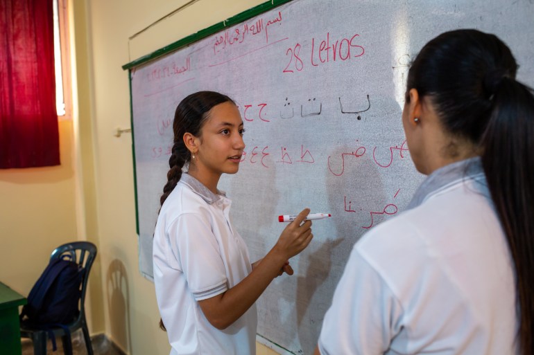 Dua siswa menulis di papan tulis di Sekolah Dar El Arkham