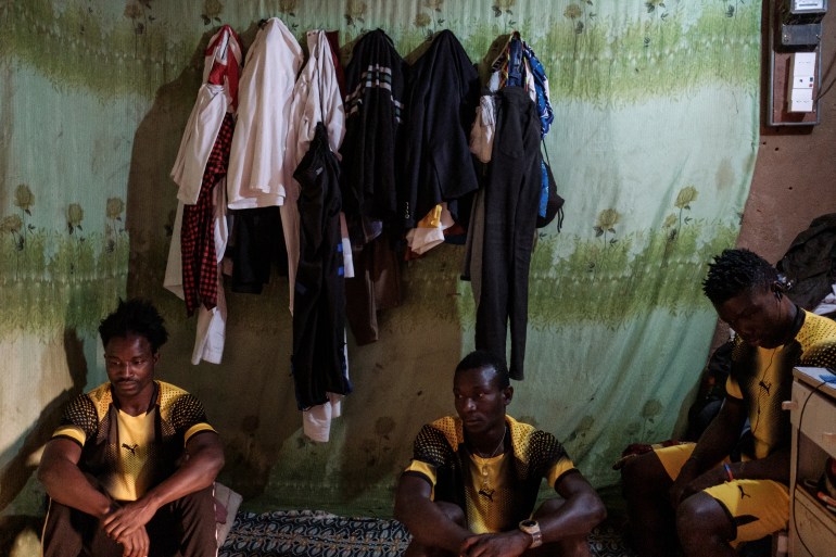 Zwannah Jackson (Left) and fellow team mates at Nassar Football club sit in the room eight of them call home in Agadez [Guy Peterson/Al Jazeera]