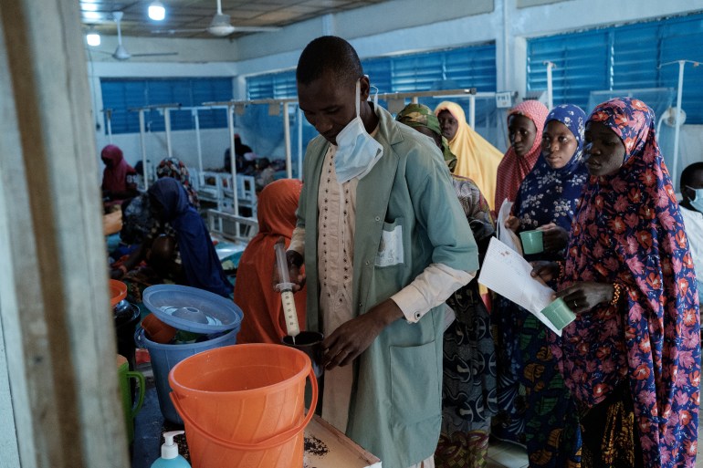 Une infirmière utilise une seringue pour remplir des gobelets pour les nourrissons qui sont traités pour la malnutrition à la clinique d'Aguia dans le sud du Niger